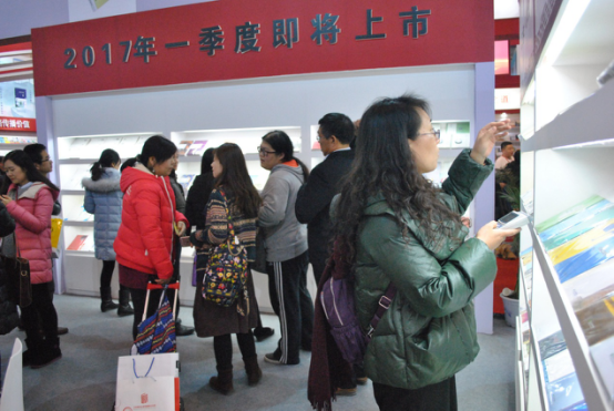 众多合作伙伴在公司展台前翻看图书、交流心得